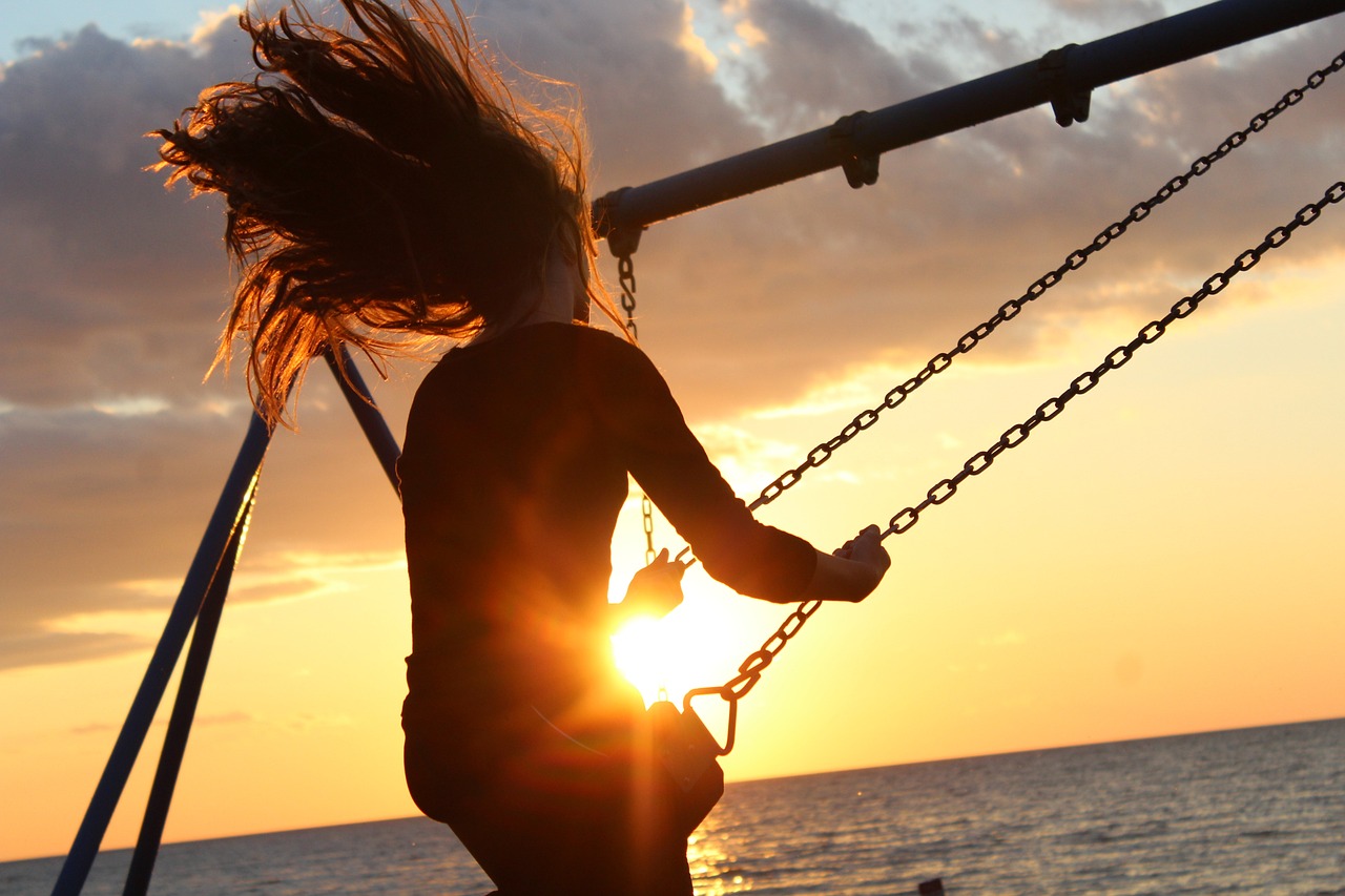 girl on a swing with sun flare